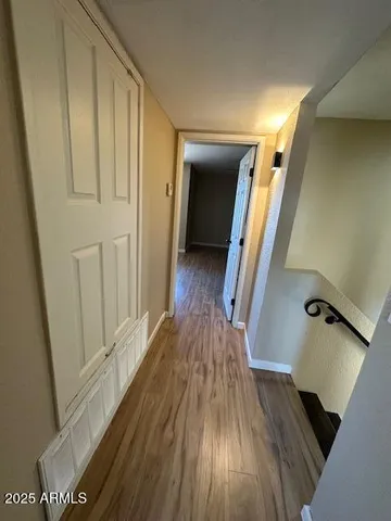 a view of a hallway with wooden floor and staircase