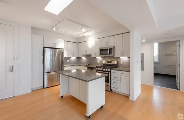 a kitchen with stainless steel appliances granite countertop a refrigerator stove microwave and sink