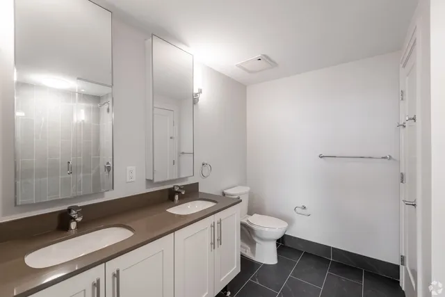 a bathroom with a granite countertop sink a toilet and a mirror