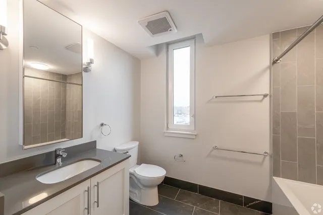 a bathroom with a granite countertop sink toilet and shower