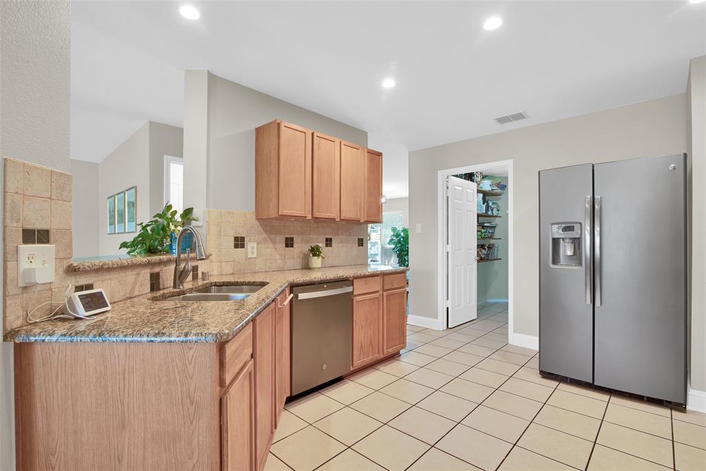 a kitchen with stainless steel appliances granite countertop a sink and a refrigerator