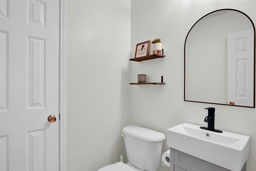 514 Brighton Ct Road Wylie, TX 75098 - Photo 10 of 25 a bathroom with a toilet sink and mirror