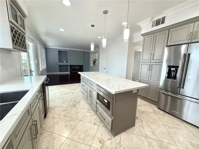 a kitchen with kitchen island a counter top space a sink stainless steel appliances and cabinets