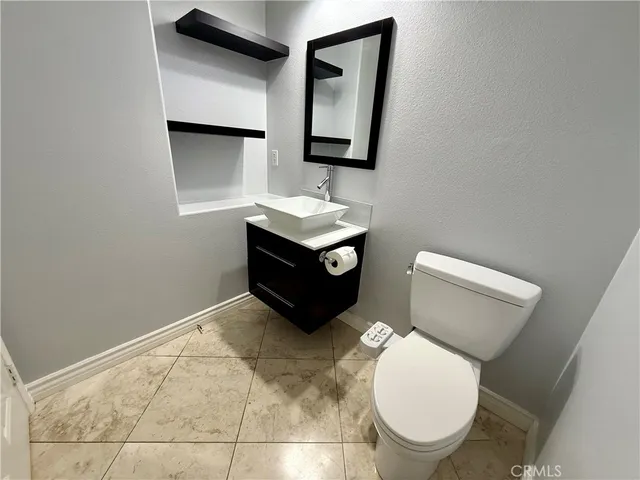 a bathroom with a toilet a sink and mirror