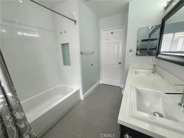 a bathroom with a tub sink and mirror
