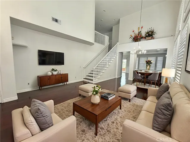a living room with furniture a flat screen tv and a chandelier