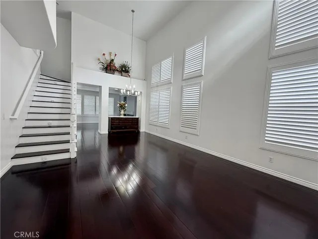 a view of a livingroom with wooden floor and a kitchen