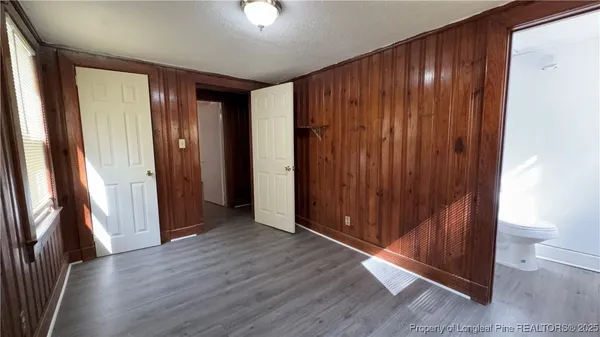 an empty room with wooden floor and a bathroom