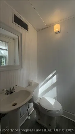 a bathroom with a sink a toilet and a mirror