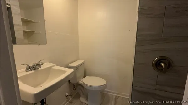 a bathroom with a sink a toilet and a mirror