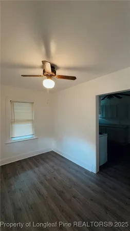 a view of empty room with wooden floor