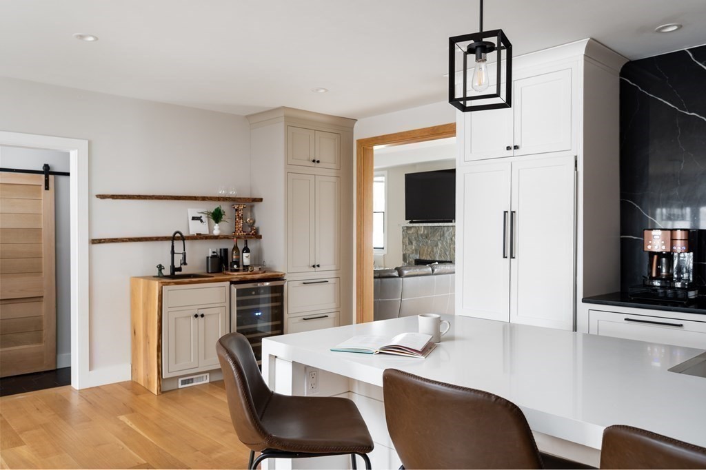100 Gerald Road Milton, MA 02186 - Photo 14 of 42 a kitchen with stainless steel appliances kitchen island granite countertop a dining table chairs and a refrigerator
