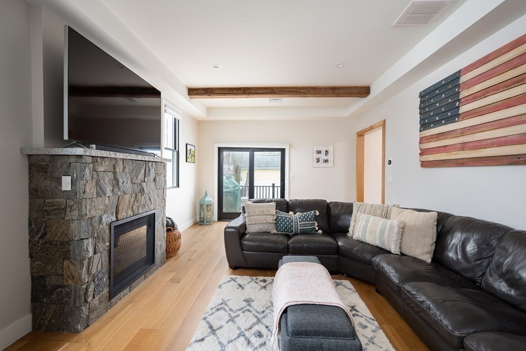 100 Gerald Road Milton, MA 02186 - Photo 20 of 42 a living room with fireplace furniture and a flat screen tv