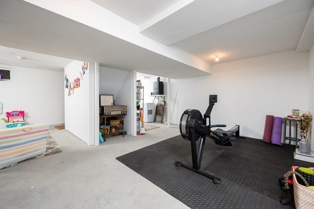 100 Gerald Road Milton, MA 02186 - Photo 25 of 42 a living room with furniture gym equipment and a chandelier