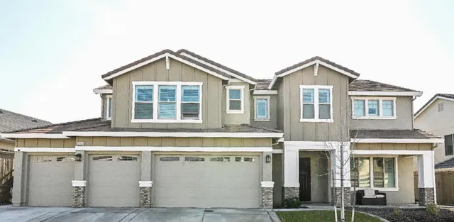 a kitchen with stainless steel appliances kitchen island granite countertop a table chairs sink and cabinets