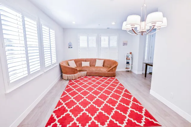a living room with furniture a flat screen tv and a window