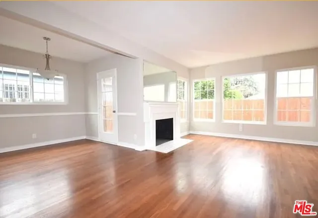 a view of a livingroom with wooden floor and a fireplace