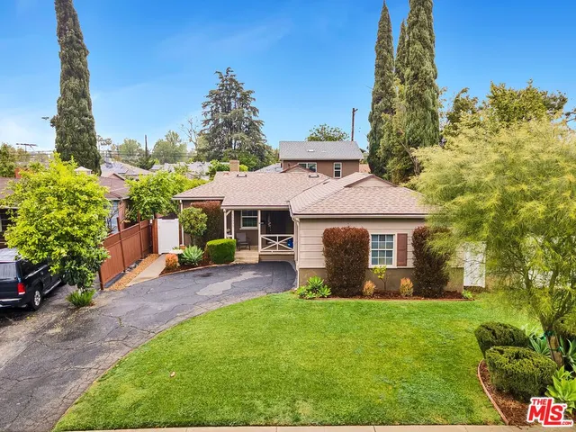 a front view of a house with a garden and yard