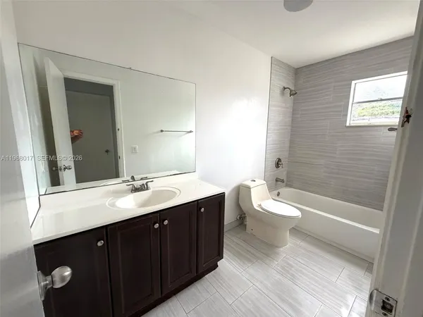 a bathroom with a double vanity sink toilet mirror and bathtub