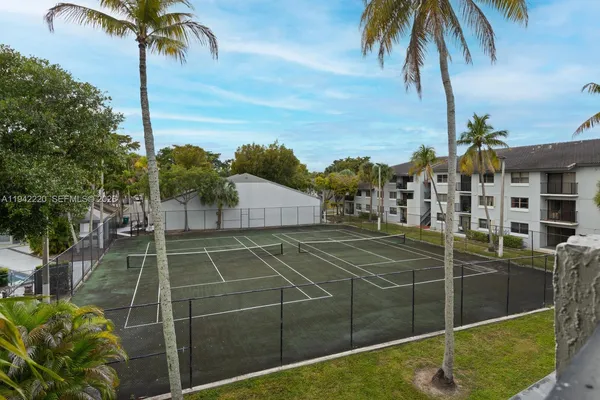 a tennis court with view of palm trees