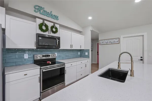 a kitchen with a sink a stove and microwave