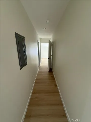 a view of a hallway with wooden floor and entryway