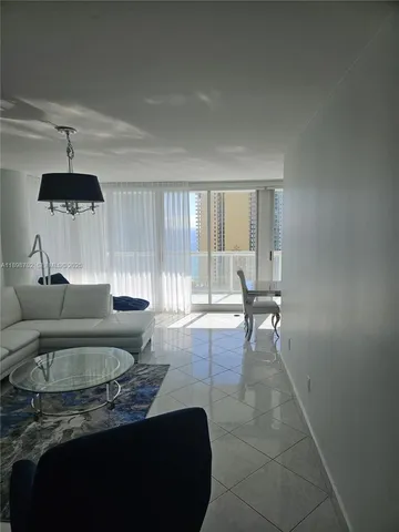 a living room with furniture and a floor to ceiling window