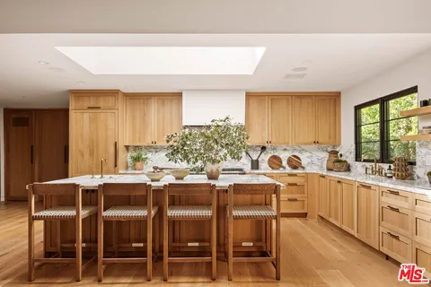 a kitchen with a sink and chairs