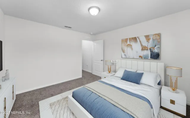 a bedroom with a bed and painting on the wall