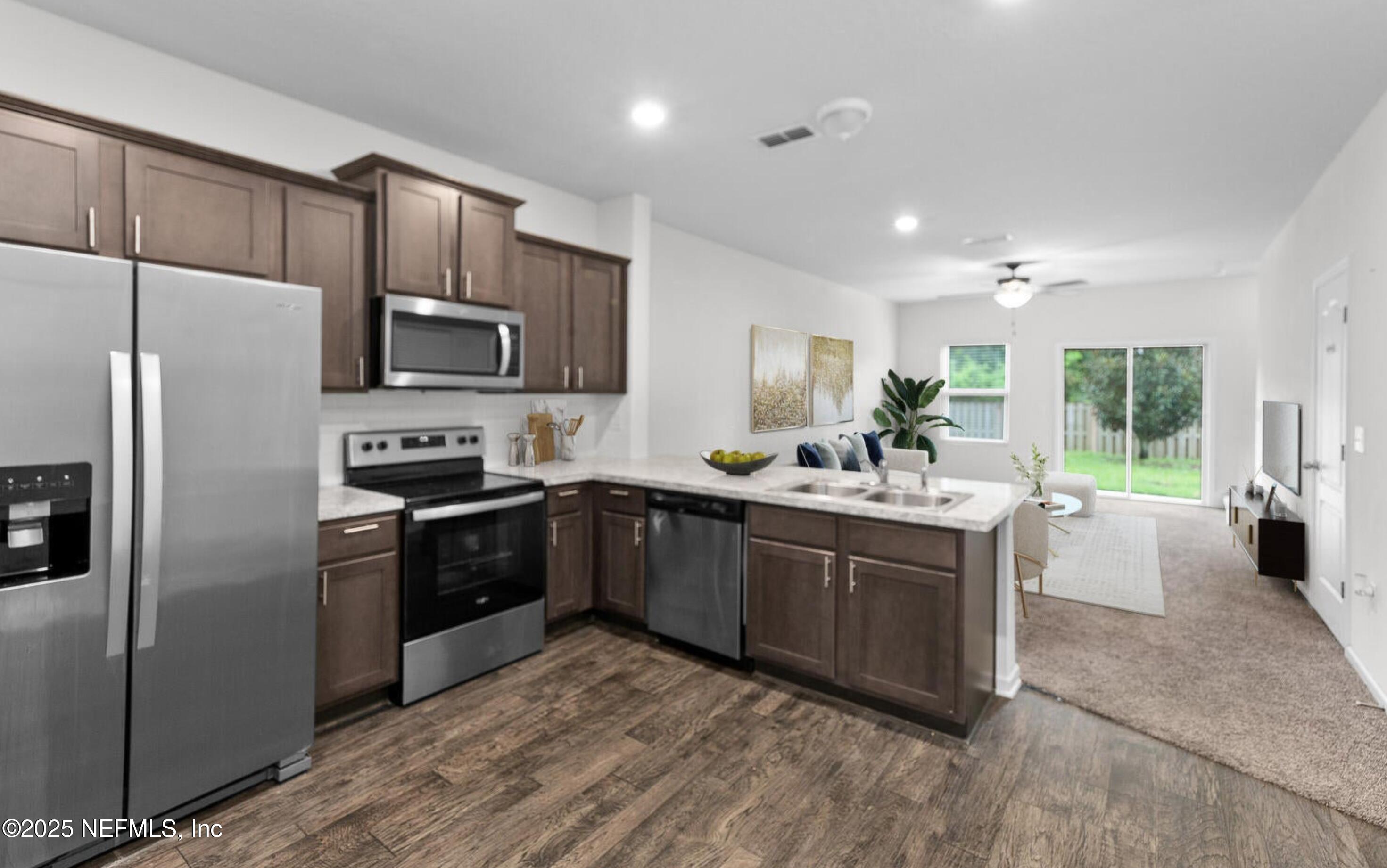 8039 Echo Springs Road Jacksonville, FL 32256 - Photo 4 of 22 a kitchen with stainless steel appliances granite countertop a sink stove refrigerator and cabinets