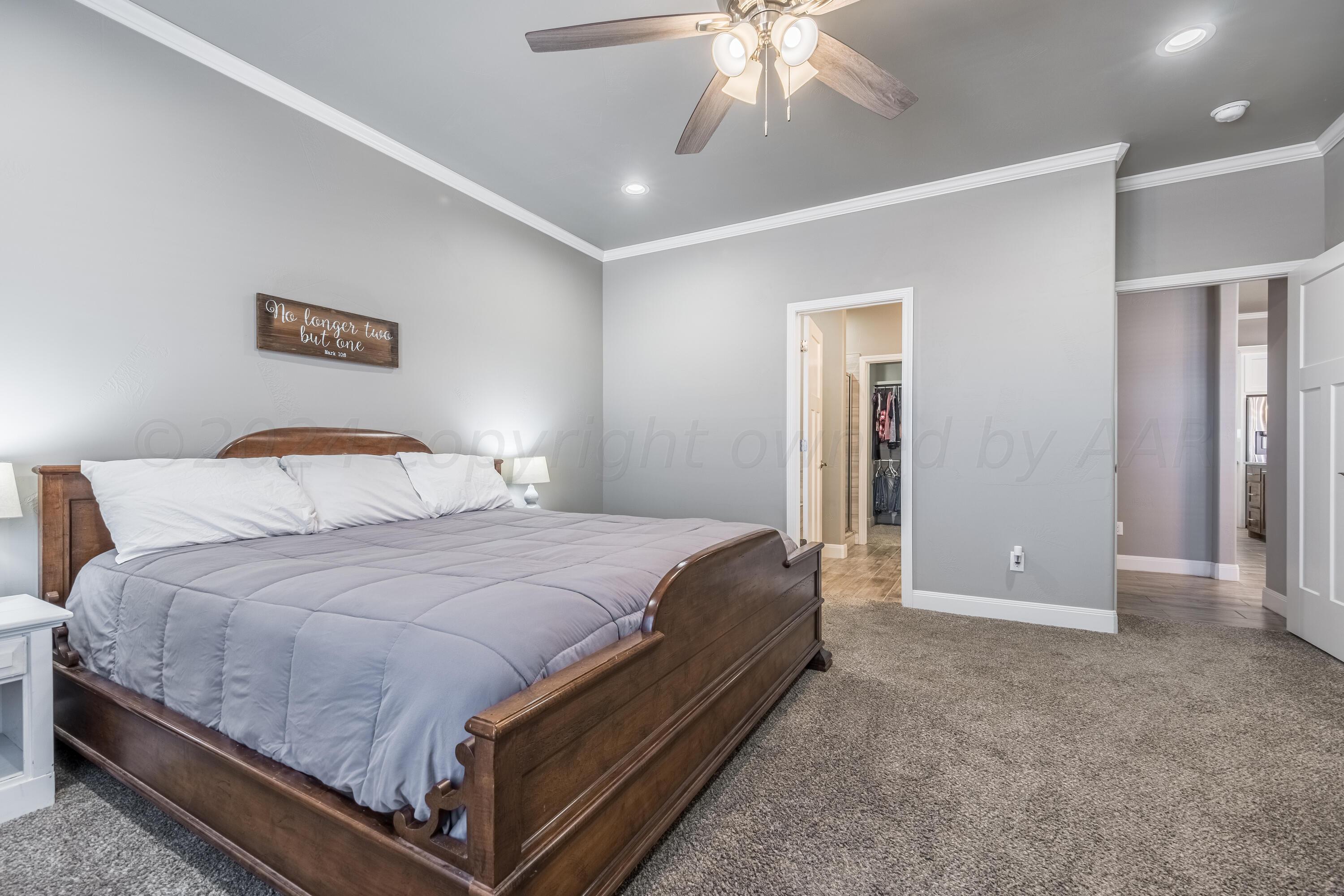 5 Gimball Drive Canyon, TX 79015 - Photo 16 of 36 a spacious bedroom with a bed and a chandelier
