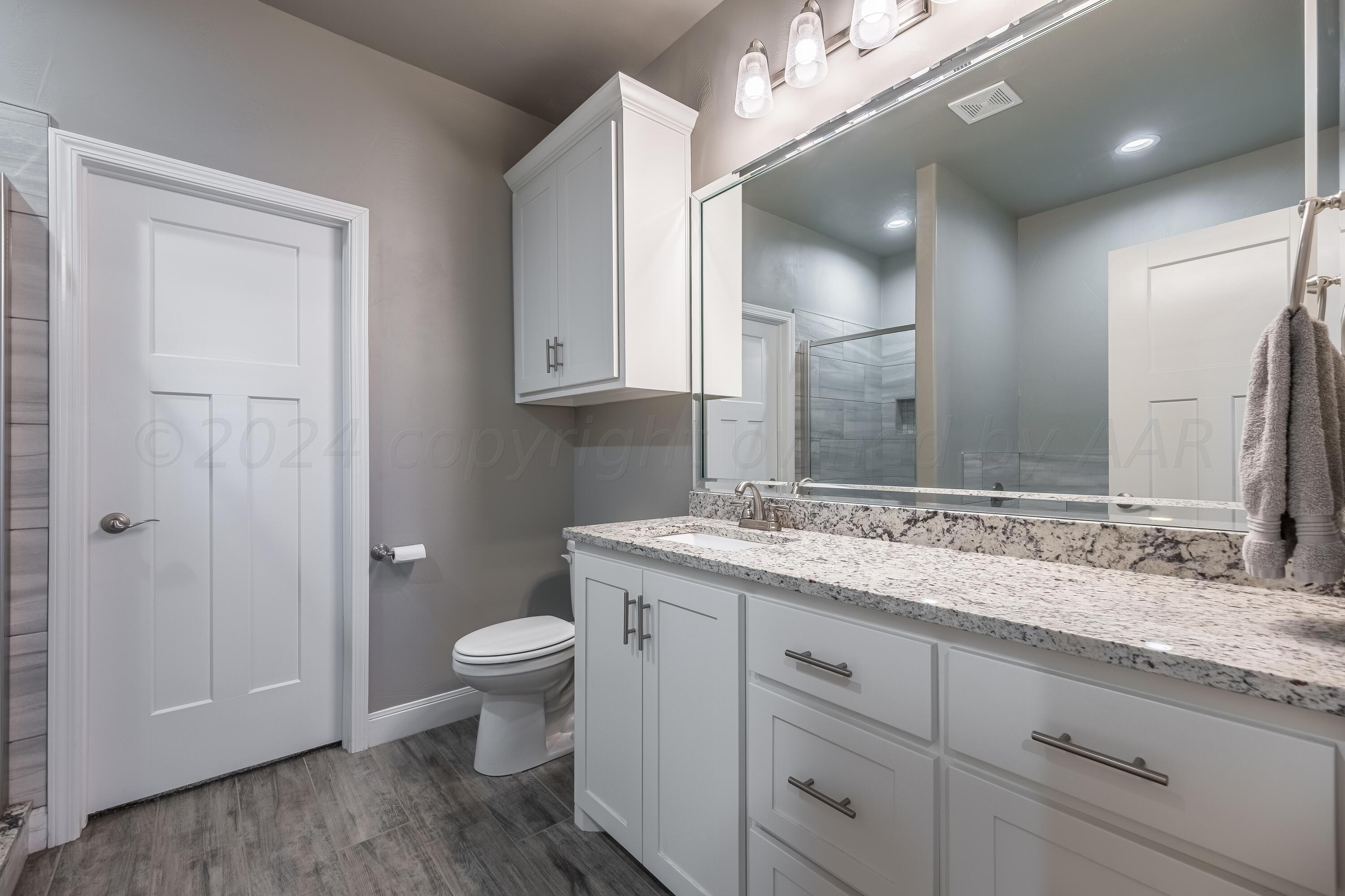 5 Gimball Drive Canyon, TX 79015 - Photo 19 of 36 a bathroom with a granite countertop sink a toilet and a mirror