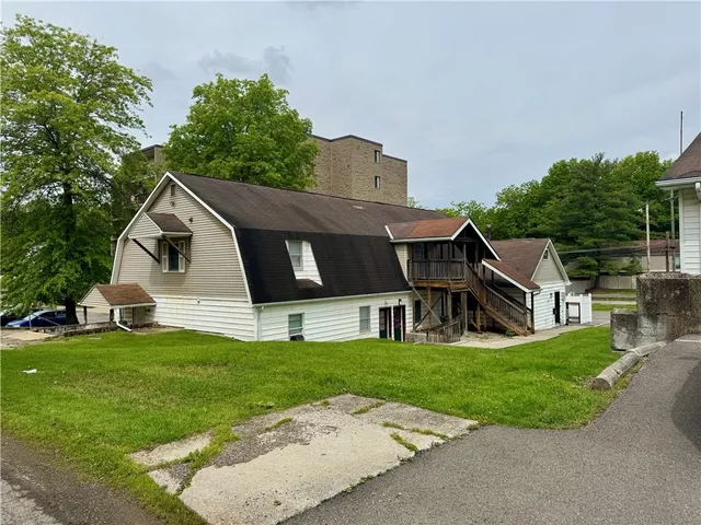 a front view of a house with a yard and trees