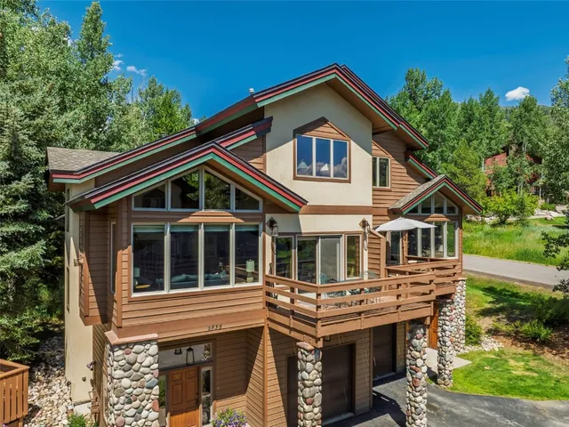 a view of house with a yard and potted plants