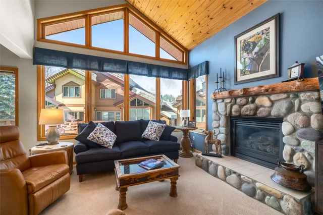 a living room with furniture a fireplace and a large window