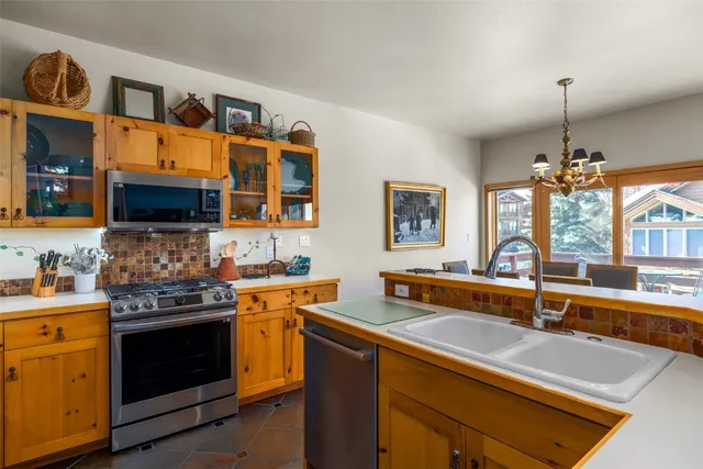 a kitchen with stainless steel appliances a stove a sink and a microwave