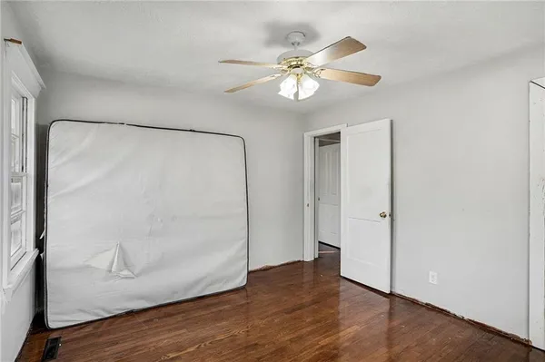 an empty room with wooden floor and mirror