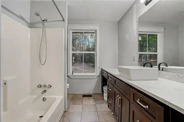 a bathroom with a granite countertop sink a toilet and shower