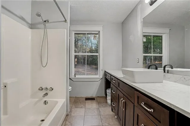 a bathroom with a granite countertop sink a toilet and shower