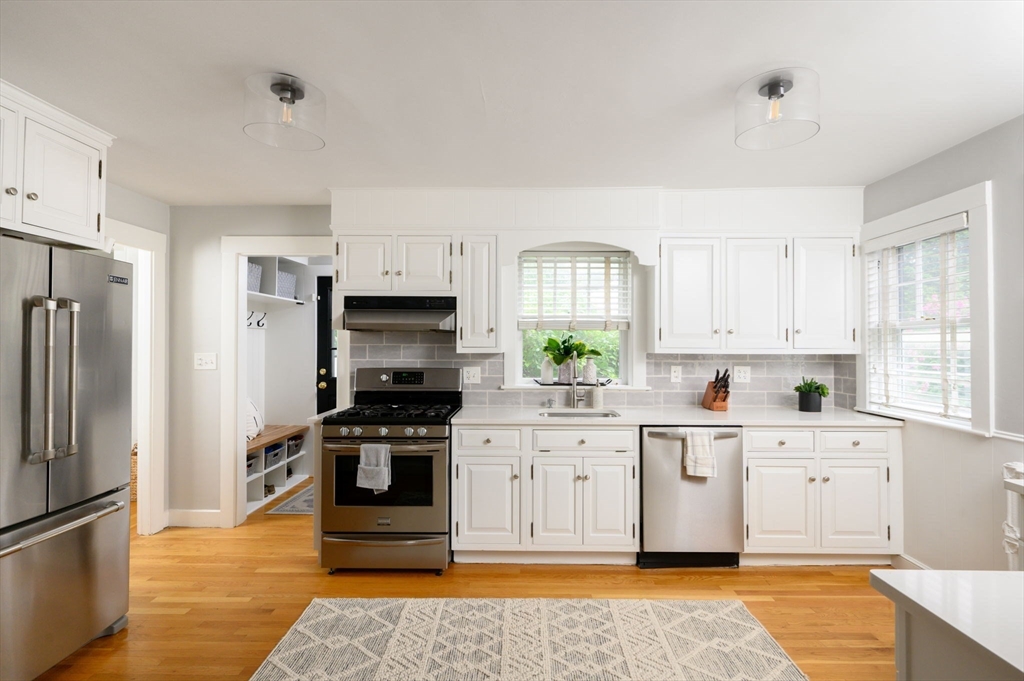 45 Rowe Street Milton, MA 02186 - Photo 2 of 34 a kitchen with white cabinets and stainless steel appliances