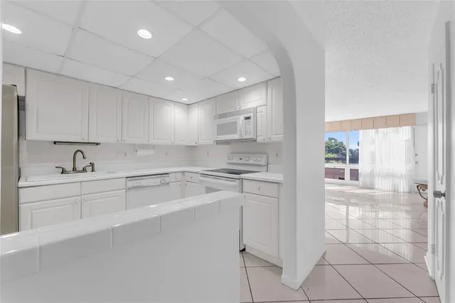a large white kitchen with cabinets