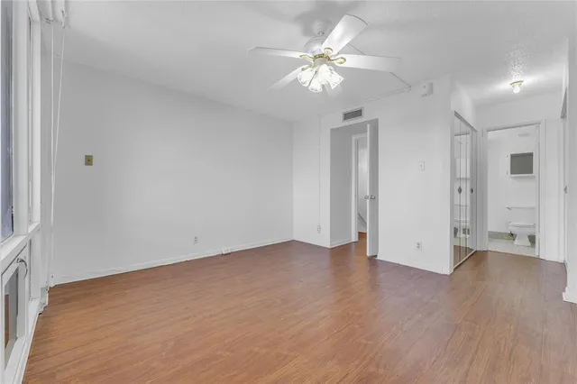 a view of an empty room with wooden floor