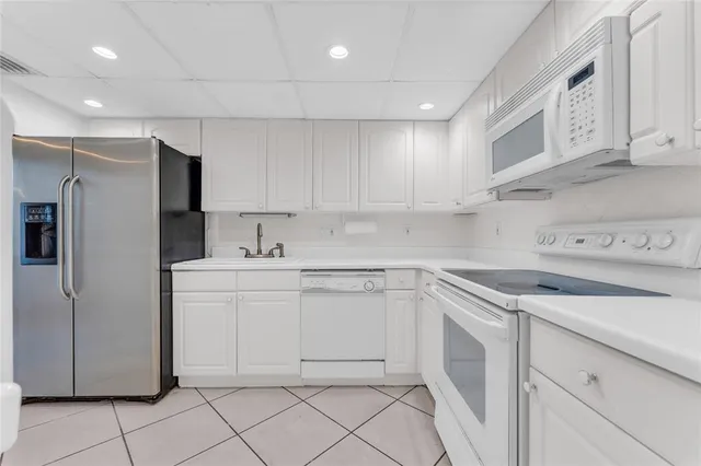 a kitchen with white cabinets and white appliances
