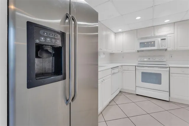 a kitchen with stainless steel appliances granite countertop white cabinets and window