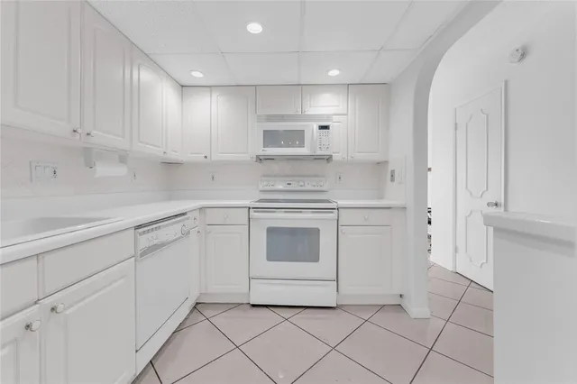 a kitchen with white cabinets and appliances