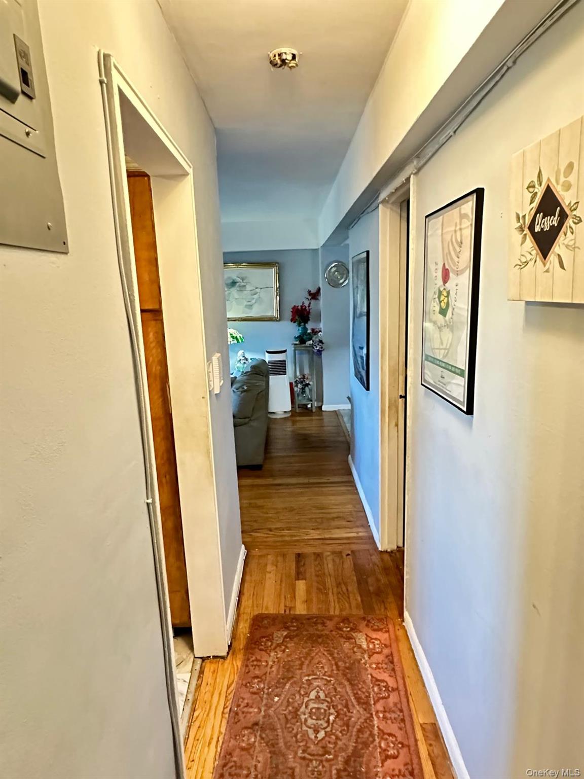 99-35 59th Avenue, Unit 5D Queens, NY 11368 - Photo 12 of 19 a view of a hallway with wooden floor and furniture