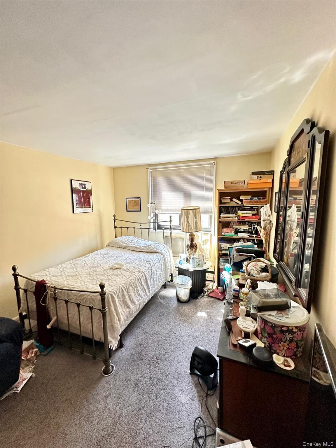 99-35 59th Avenue, Unit 5D Queens, NY 11368 - Photo 13 of 19 a bedroom with a bed gym equipment and view of living room