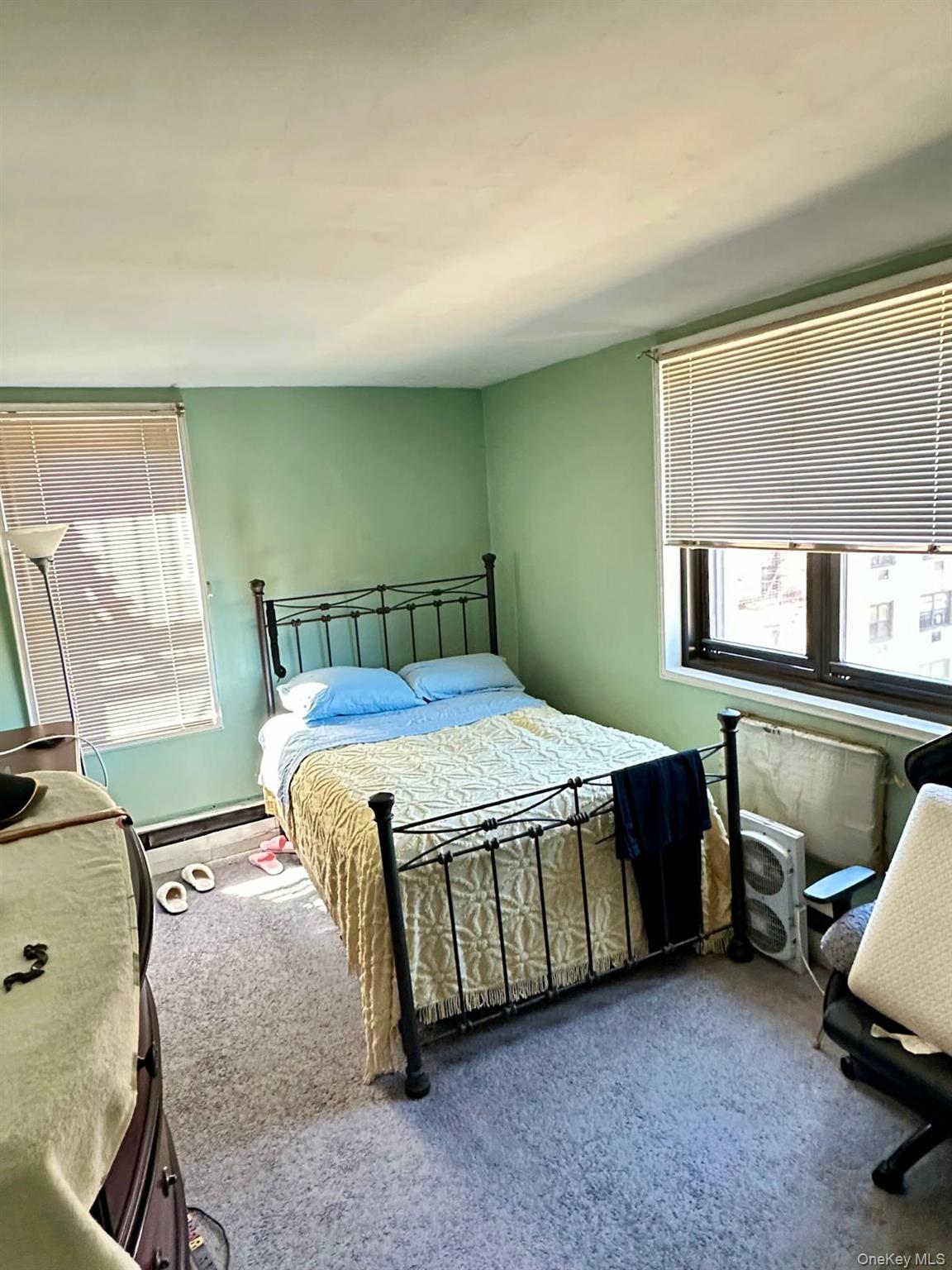 99-35 59th Avenue, Unit 5D Queens, NY 11368 - Photo 16 of 19 a bed sitting in a room next to a window