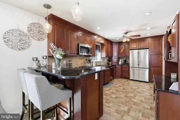 a kitchen with granite countertop a sink stainless steel appliances and cabinets