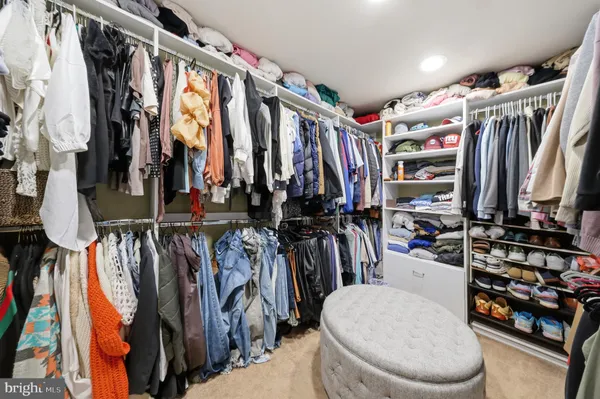 a view of walk in closet with clothes and shoes